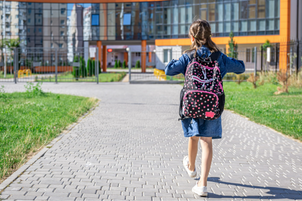 menina chegando à escola com mochila às costas